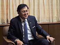 笑顔でインタビューに応じる菊地裕太郎会長